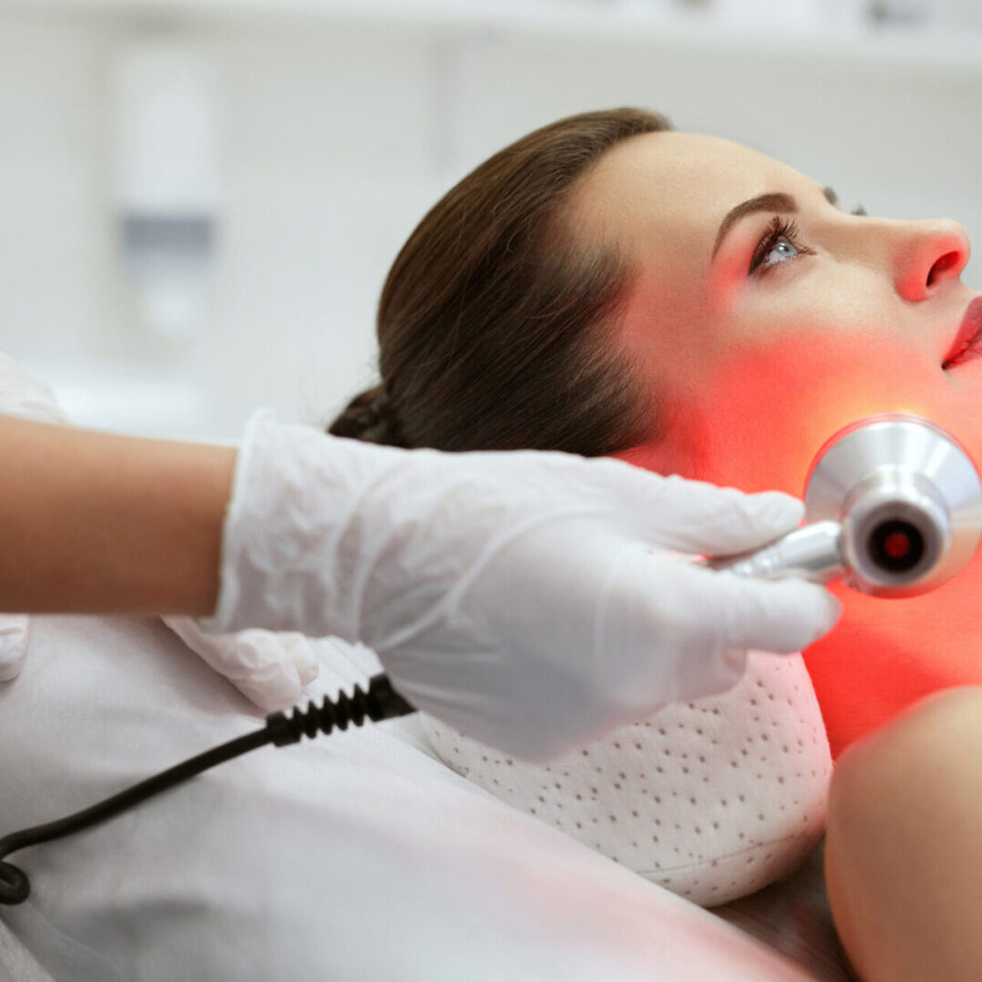 Facial Beauty Treatment. Woman Doing Red Led Light Therapy LED Skin Care Spa