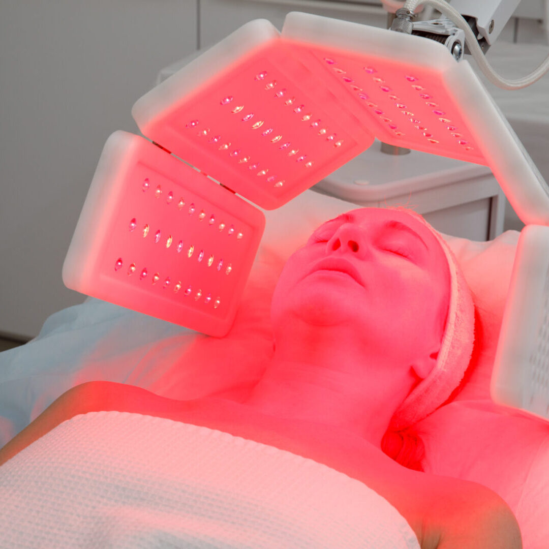 An elderly woman undergoes a facial rejuvenation procedure. Woman face lt Red light treatment At beauty clinic. Cosmetology. LED Skin Care Spa