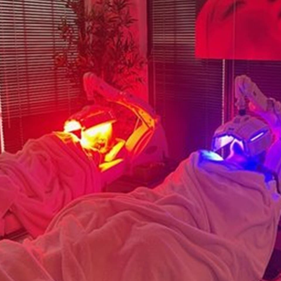 Two people laying in bed with red and blue lights